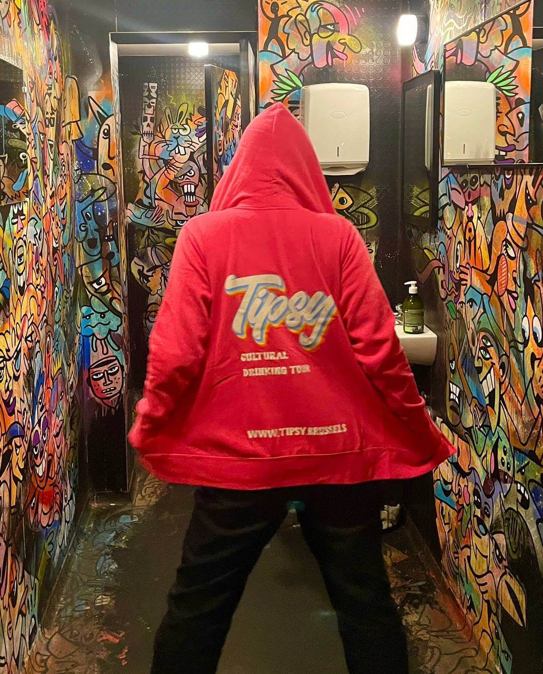 girl with tipsy hoodie in a grafiti bathroom